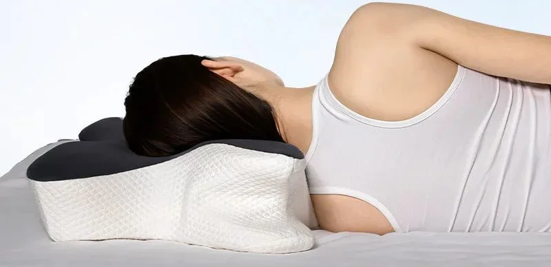 Una mujer duerme de lado, con la cabeza sobre el ala de la almohada mariposa